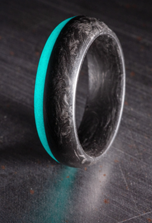 Forged Carbon Fiber Ring with turquoise glow on the out rim of one side.
