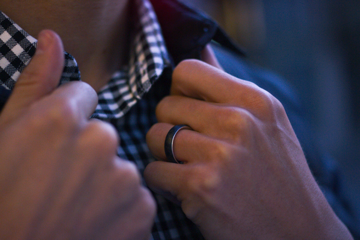 Forged carbon fiber ring with a silver interior featured on a hand model. 
