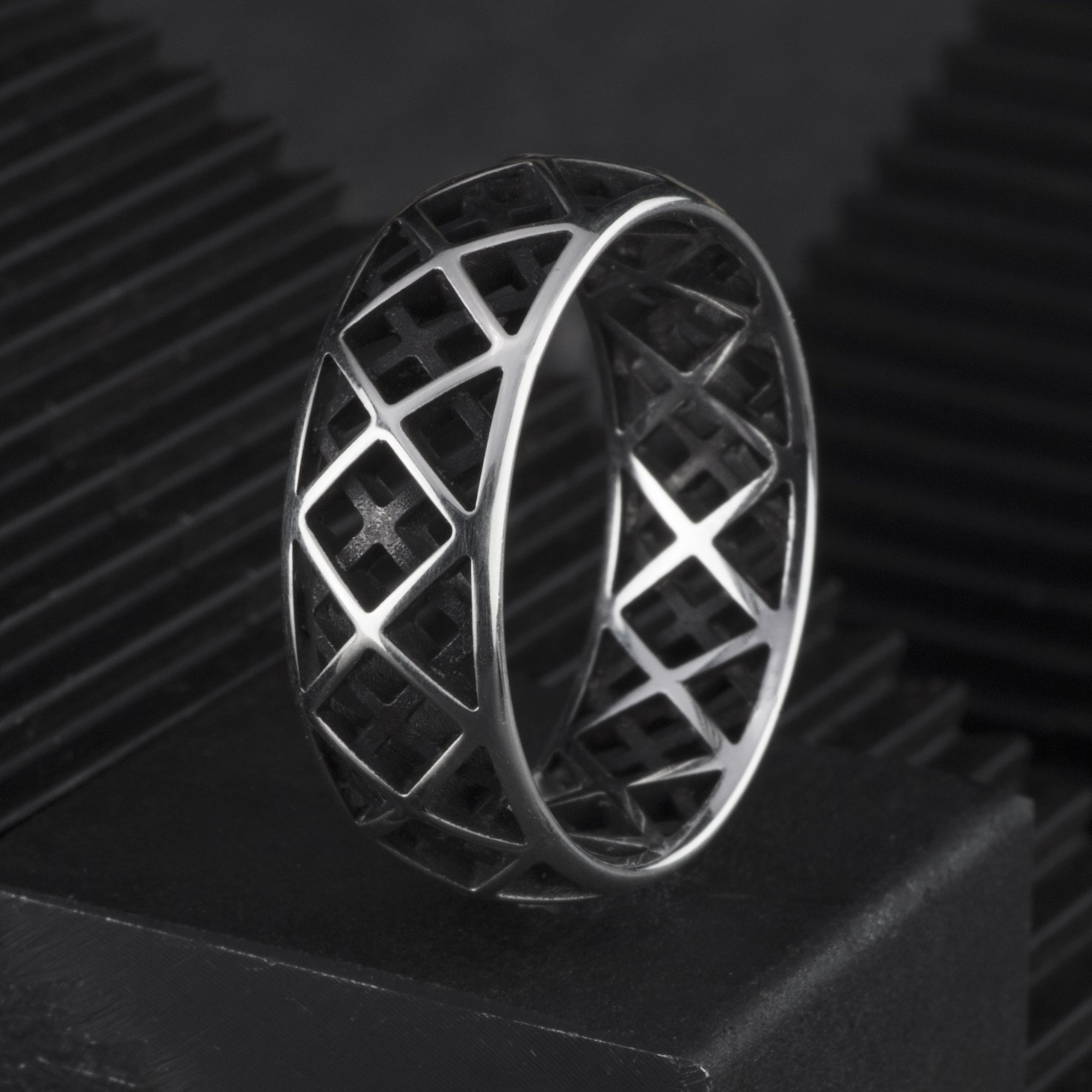 Sterling silver ring featuring a triangular pattern and a blackened interior. 