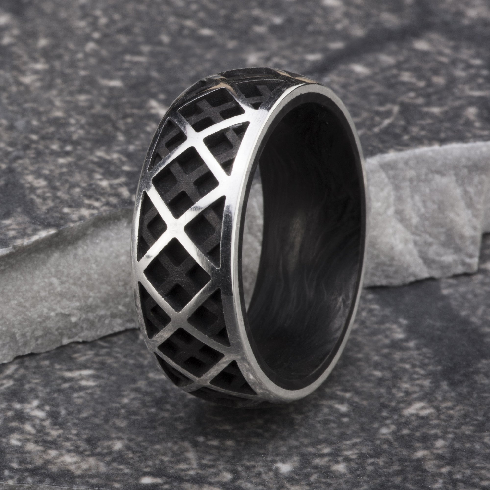 Sterling silver ring featuring a triangular pattern exterior and forged carbon fiber interior. 
