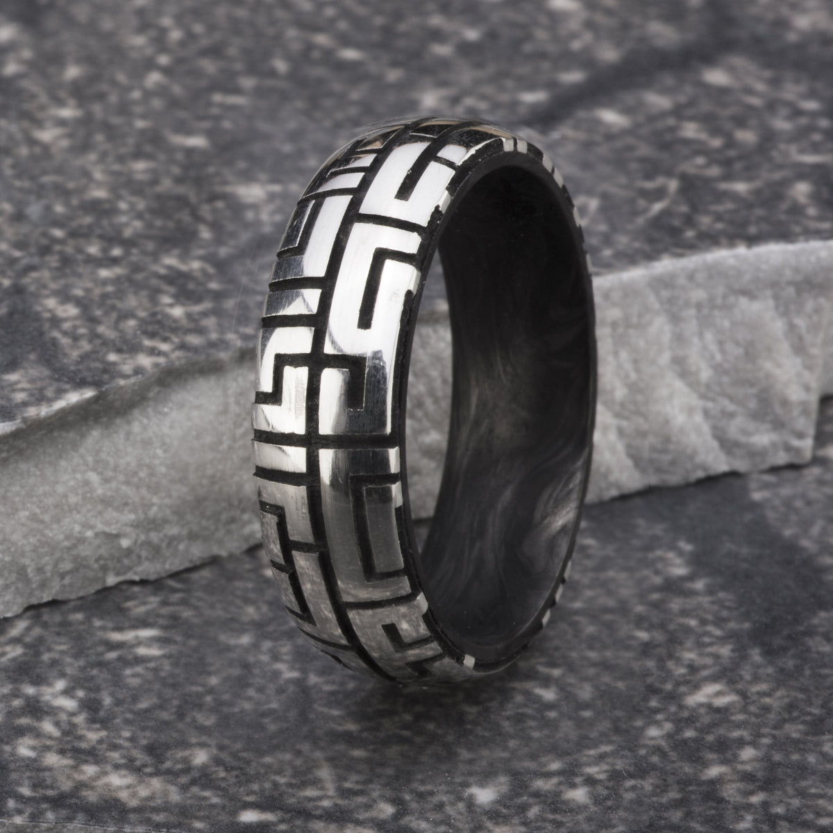 Sterling silver ring with a maze pattern exterior and forged carbon fiber interior. 
