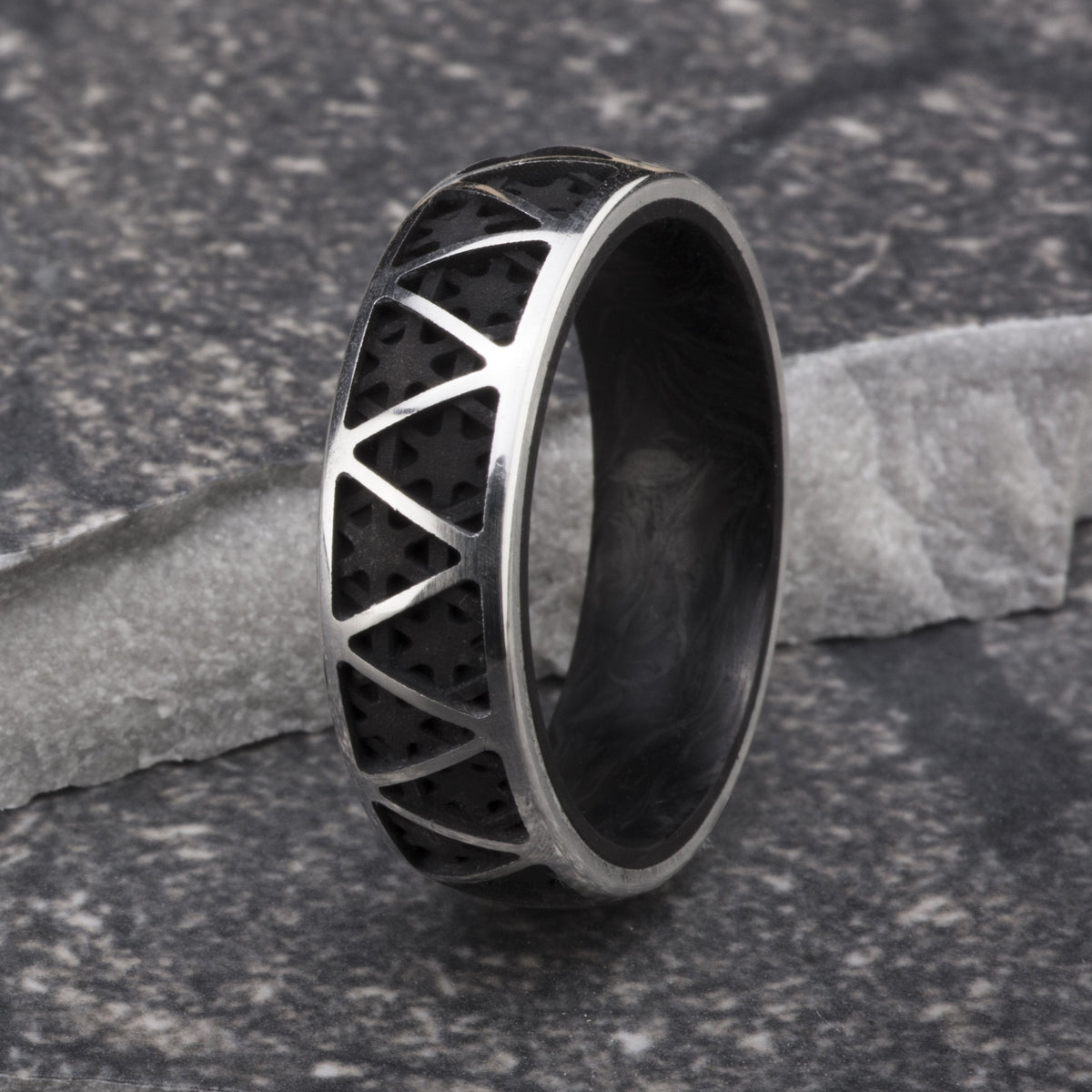 Sterling silver ring featuring a triangular pattern and a forged carbon fiber interior. 