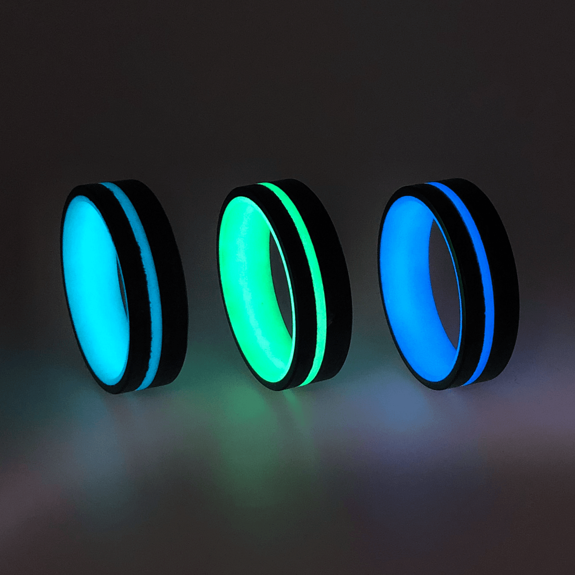 Turquoise, Green, and Blue Glow Rings with Forged Carbon Fiber exterior and a center glow stripe.