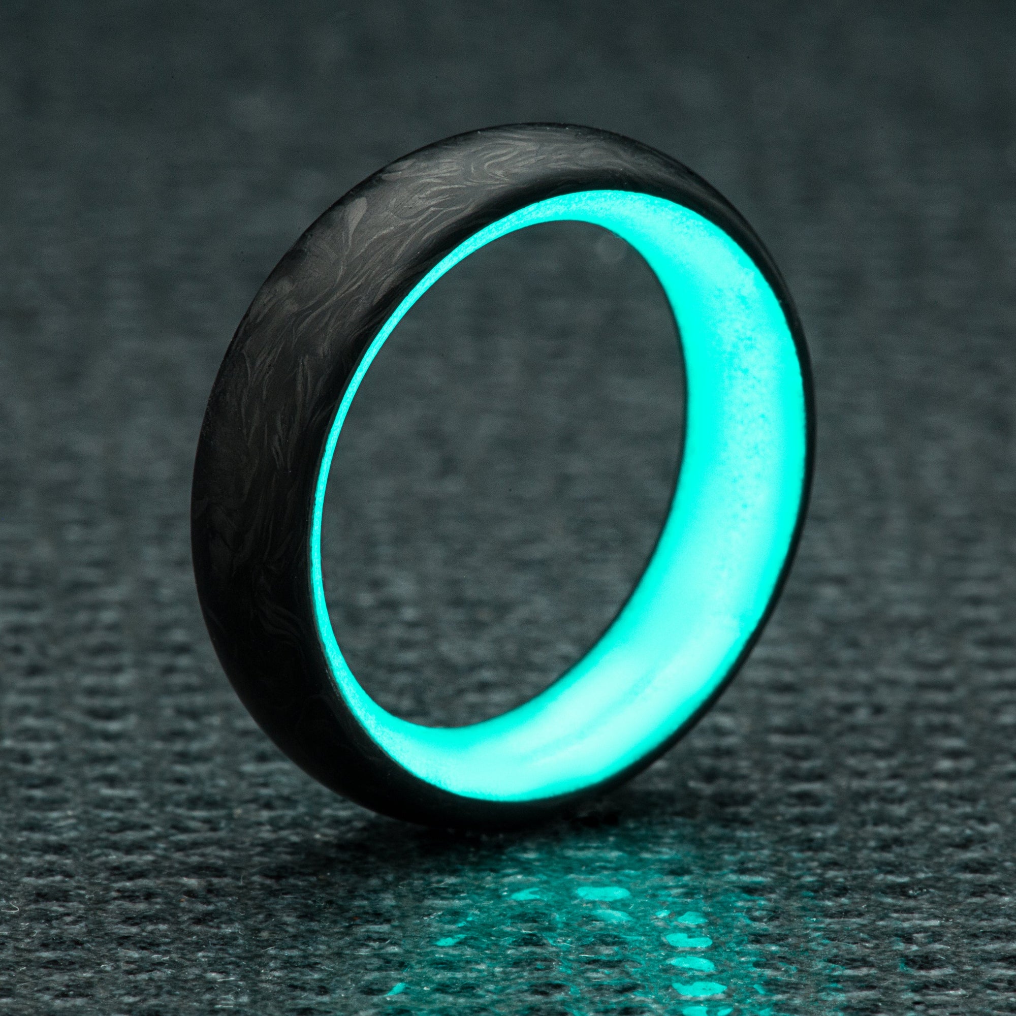 Carbon fiber radius ring with turquoise glow insert. 