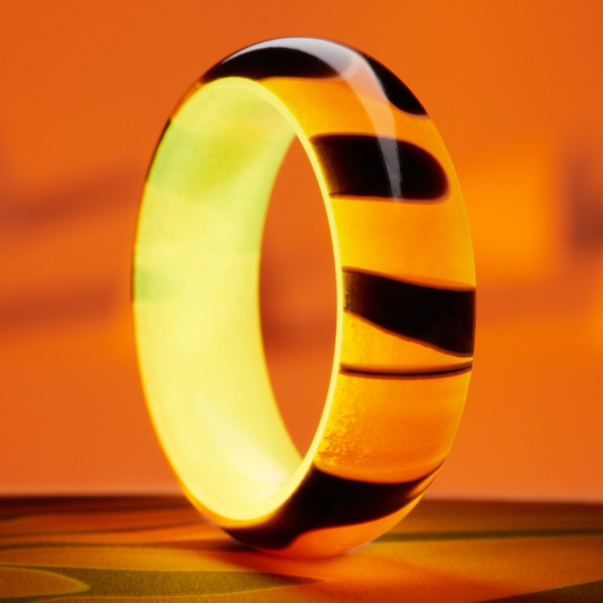 Ring with black and orange resin exterior with orange glow interior. 