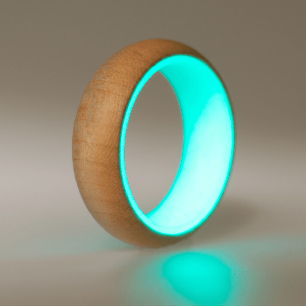 Turquoise glow ring with a maple wood exterior. 