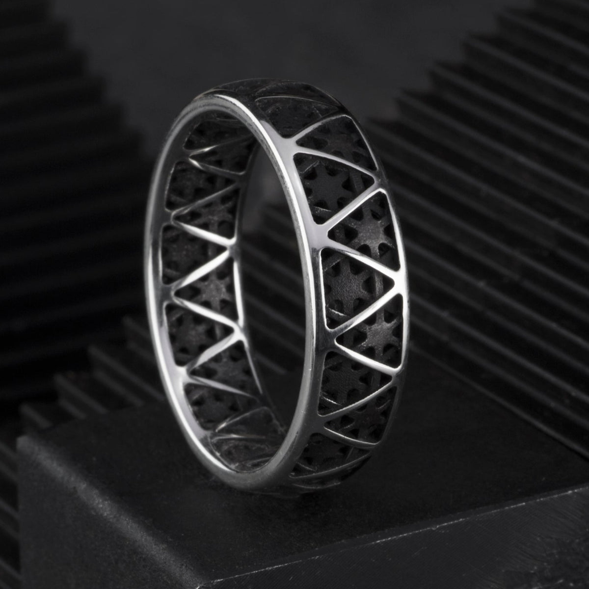 Ring featuring a sterling silver exterior with a triangular pattern and a blackened interior and triangular pattern.