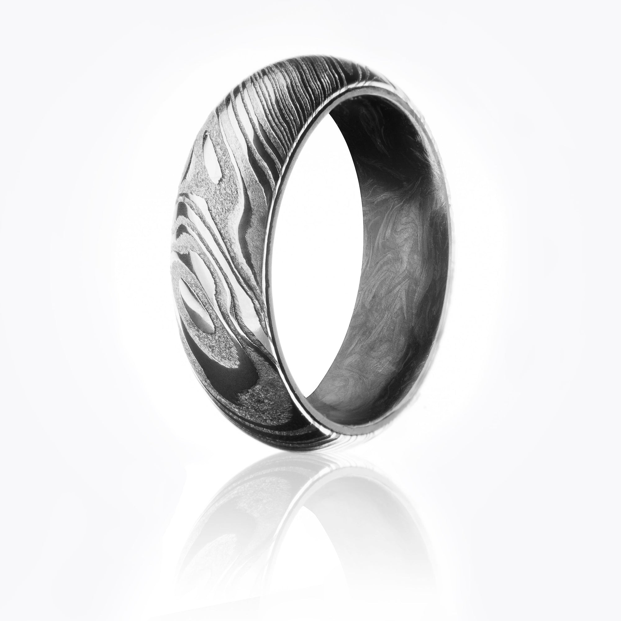 Damascus Steel ring with textured woodgrain patterned exterior and forged carbon fiber interior. 